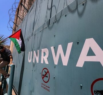 Palestinian With National Flag Outside UNRWA Barricade