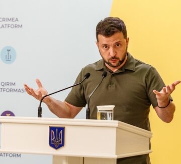 Ukrainian President Volodymyr Zelensky Speaking At A Podium In Kyiv