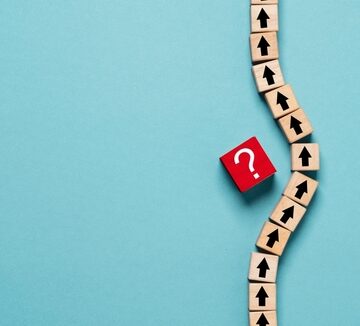 Black Arrow On Wooden Blocks Aiming Upward With Another Block With Red Question Mark