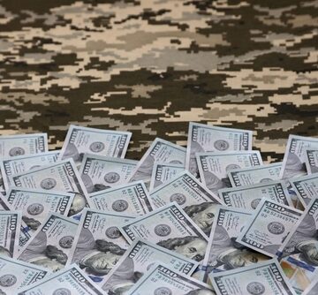 A Spread Of U.S. Dollar Bills On Carpet With A Pattern Of The Ukrainian Military