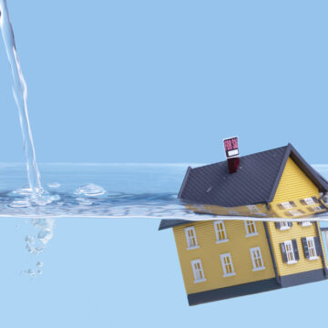 Model Home Halfway Under Water Representing Real Estate Crisis Concept,