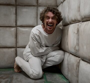 Crazy Man Wearing Straitjacket Laughing In Padded Room