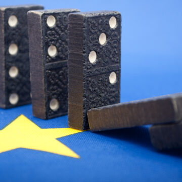 Falling Dominos Atop The European Union Flag
