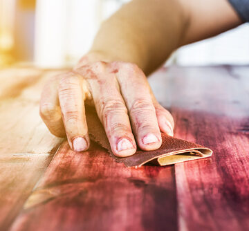 Hand Sanding And Removing Paint From A Wood Surface
