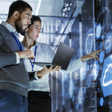 Man And Woman Analyzing A Wall Of Futuristic Data