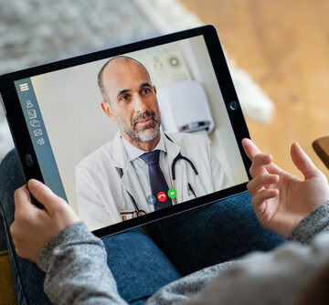 Back View Of Woman Making Video Call With Her Doctor