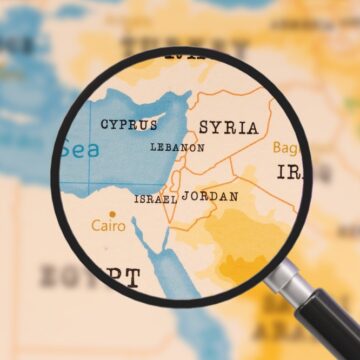 A Magnifying Glass Looking Over A Map Of The Middle East