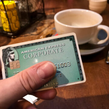 A Man Using An American Express Card To Pay Dinner Bill