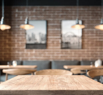 Empty,Coffee,Table,Over,Defocused,Coffee,Shop,Background,With,Copy Empty Tables And Booths At Coffee Shop