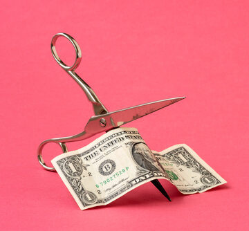 Concept Of Cutting One Dollar With Scissors On Pink Background