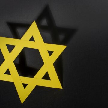 Yellow Star Of David With Shadow On Black Background