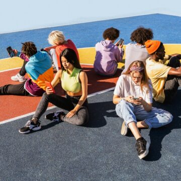 Group Of Multicultural Youth Sitting In A Circle On Their Smartphones