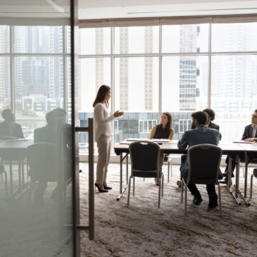 Business Team Talking At Meeting In Windowed Conference Room
