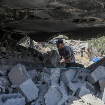 Palestinians Inspect The Site Of An Israeli Airstrike In Deir.
