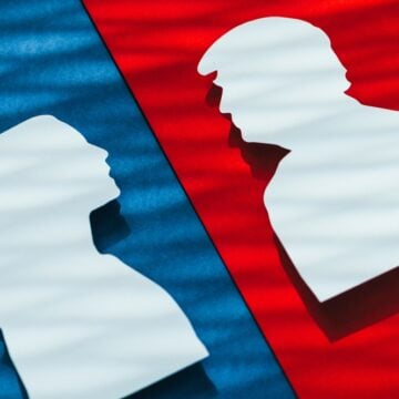 Cardboard Silhouette Cutouts Of Kamala Harris And Donald Trump Against Blue And Red Backgrounds