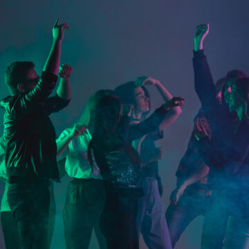 Group Of People Cheering And Dancing At A Dance Party