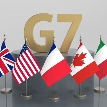 The G7 Logo In Large Gold Letters Surrounded By The Flags Of The Group Of Seven (G7)