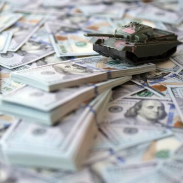 Toy Tank Sits Atop A Pile Of Hundred Dollar Bills