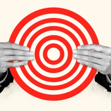 A Businessman's Hands Holding A Paper Wall Target