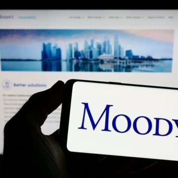 Person Holding Smartphone With Moody's Logo On The Screen