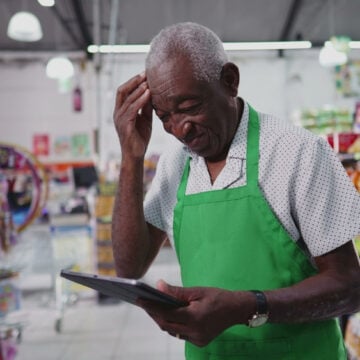 Store Clerk Checking Prices And/Or Inventory On A Tablet