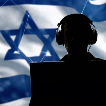 Silhouette Of A Military Man In Headphones At A Laptop With The Israeli Flag In Background