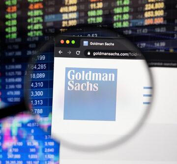 Stock Ticker Price Wall In Background With Magnification Of Goldman Sachs Company Logo