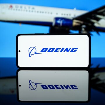 The Boeing Company Logo With A Boeing Jet In The Background