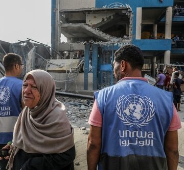 Palestinians With UNRWA Workers At The Site Of An Israeli Airstrike
