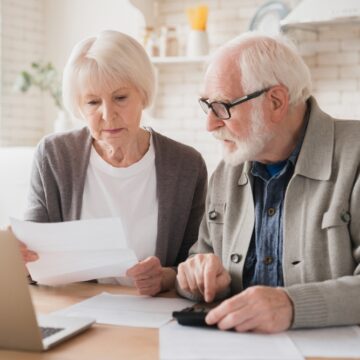 Senior Couple Reviewing Bills With A Calculator