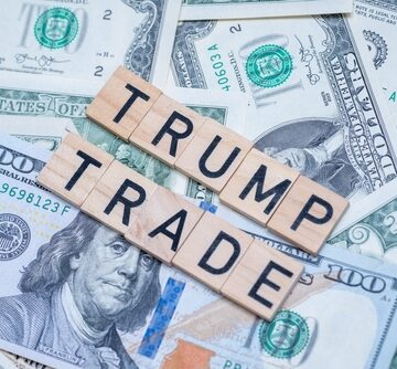 A Pile Of U.S. One Hundred Dollar Bills With Scrabble Pieces Spelling Out Donald Trump On Top