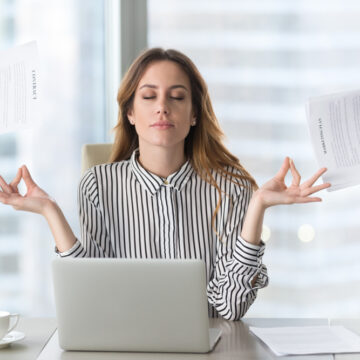 Calm,Female,Executive,Meditating,Taking,Break,At,Work,For,Mental Zen-like Female Executive Being Calm While Bombarded By Multiple Distractions
