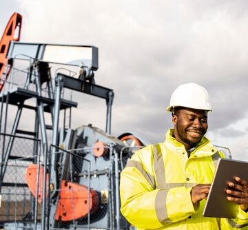 Oil Worker Standing In Front Of An Oil Rig