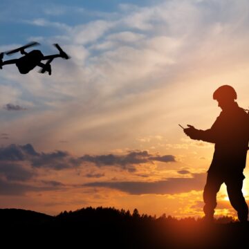 Silhouette Of Soldier In The Field Operating A Drone