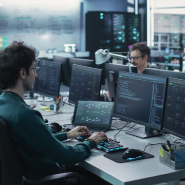 Stock Trading Room With Traders In Front Of Multiple Screens