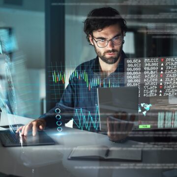 Young Businessman Using Various Technology For Stock Financial Data