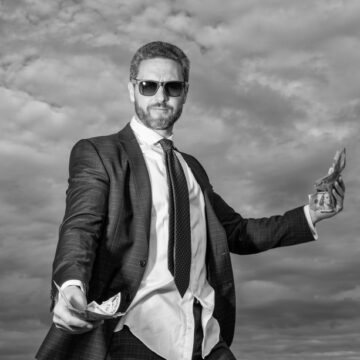 Rich Billionaire Man In Suit With Money In Both Hands