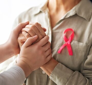 Female Patient Wearing Pink Ribbon And Listening To Doctor