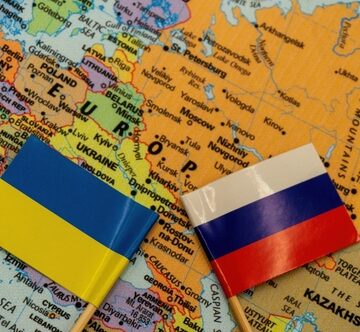 The Ukrainian And Russian Flags Placed On A Map Of Europe