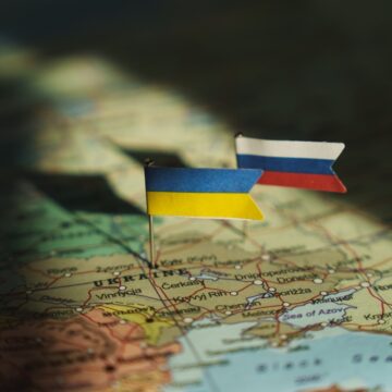 The Ukrainian And Russian Flags Pinned On A Map