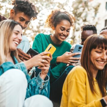 A Group Of College-age Young People Using Mobile Phones