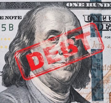 Red Stamp Of The Word "Debt" On A Benjamin Franklin One Hundred Dollar Bill