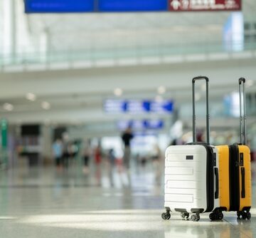 Two Suitcases Sit In An Empty Airport Terminal