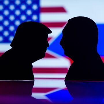 Silhouettes Of Donald Trump And Vladimir Putin With US And Russian Flags In The Background