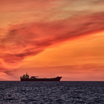 Container Ship Against A Bright Orange Sunset