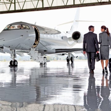 Businesswoman And Businessman Walking Toward A Private Jet