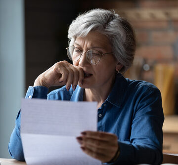 Distressed Older Woman Reviewing Bills