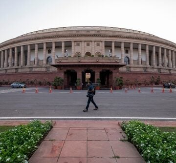 A Camera Crew Passing In Front Of The Parliament Building In New Delhi, India