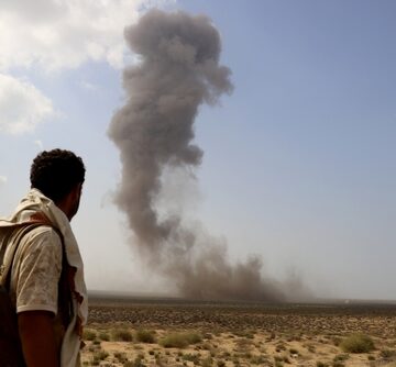 An Armed Man Looks At An Explosion In The Distance Near Hajjah, Yemen