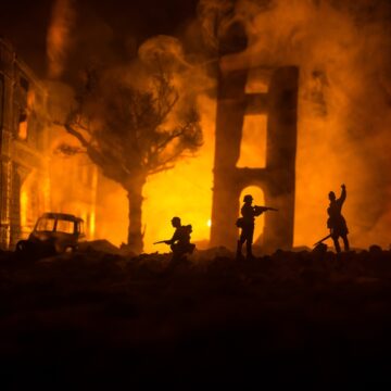Concept Image Of Soldier Silhouettes Fighting With Backdrop Of Burning Buildings At Night